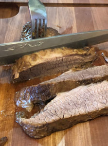 Instant Pot Brisket slicing cooked meat on board to show grain