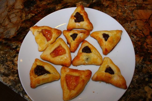 Baked pastries, with a varieties of fillings, ready to eat, served on a white platter.