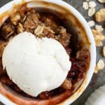 fruit crisp pinterest image with small white bowl topped with ice cream