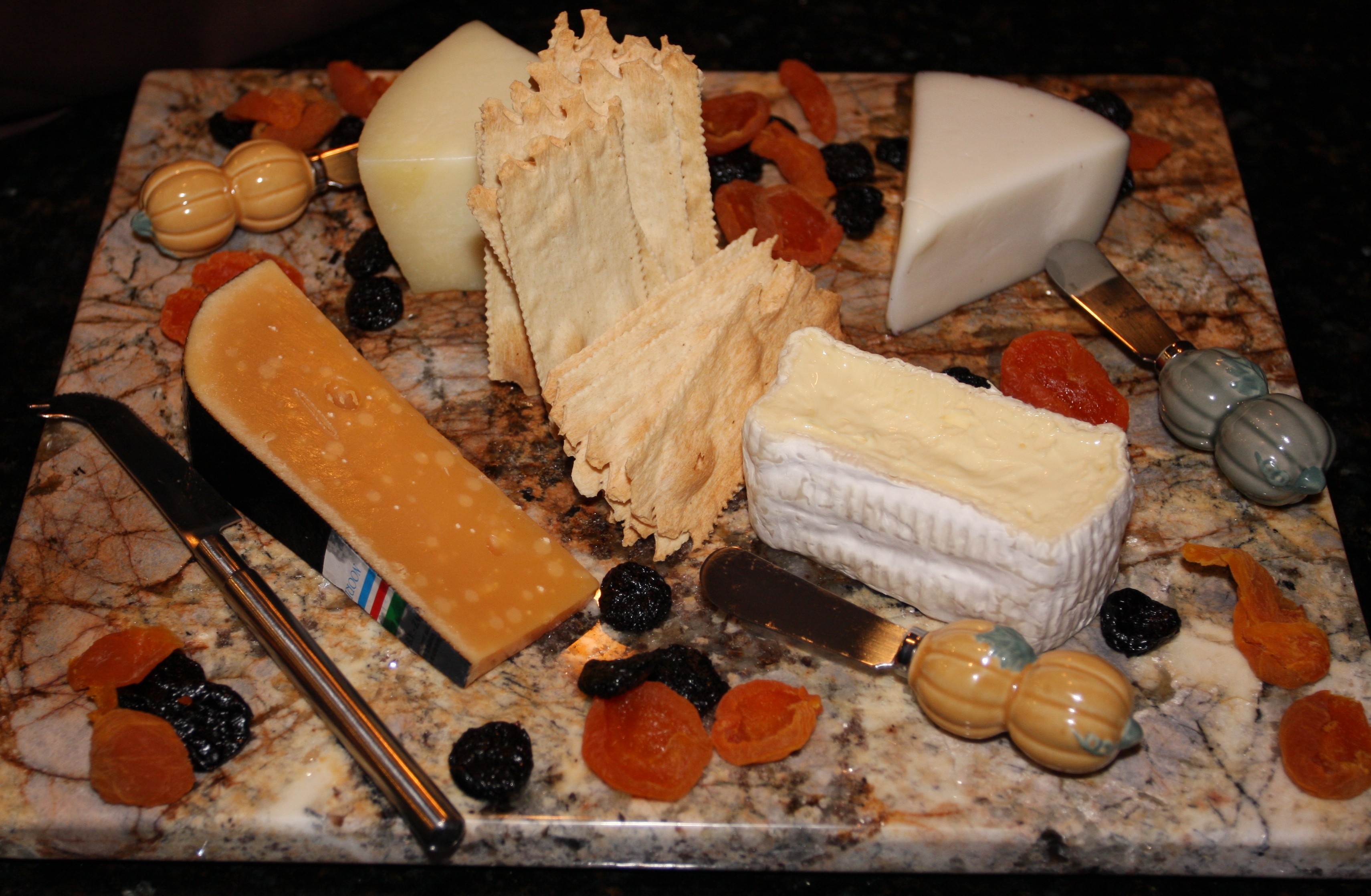 Charcuterie board with cheeses and dried fruits.