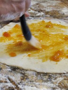 spreading apricot jam on rugelach dough