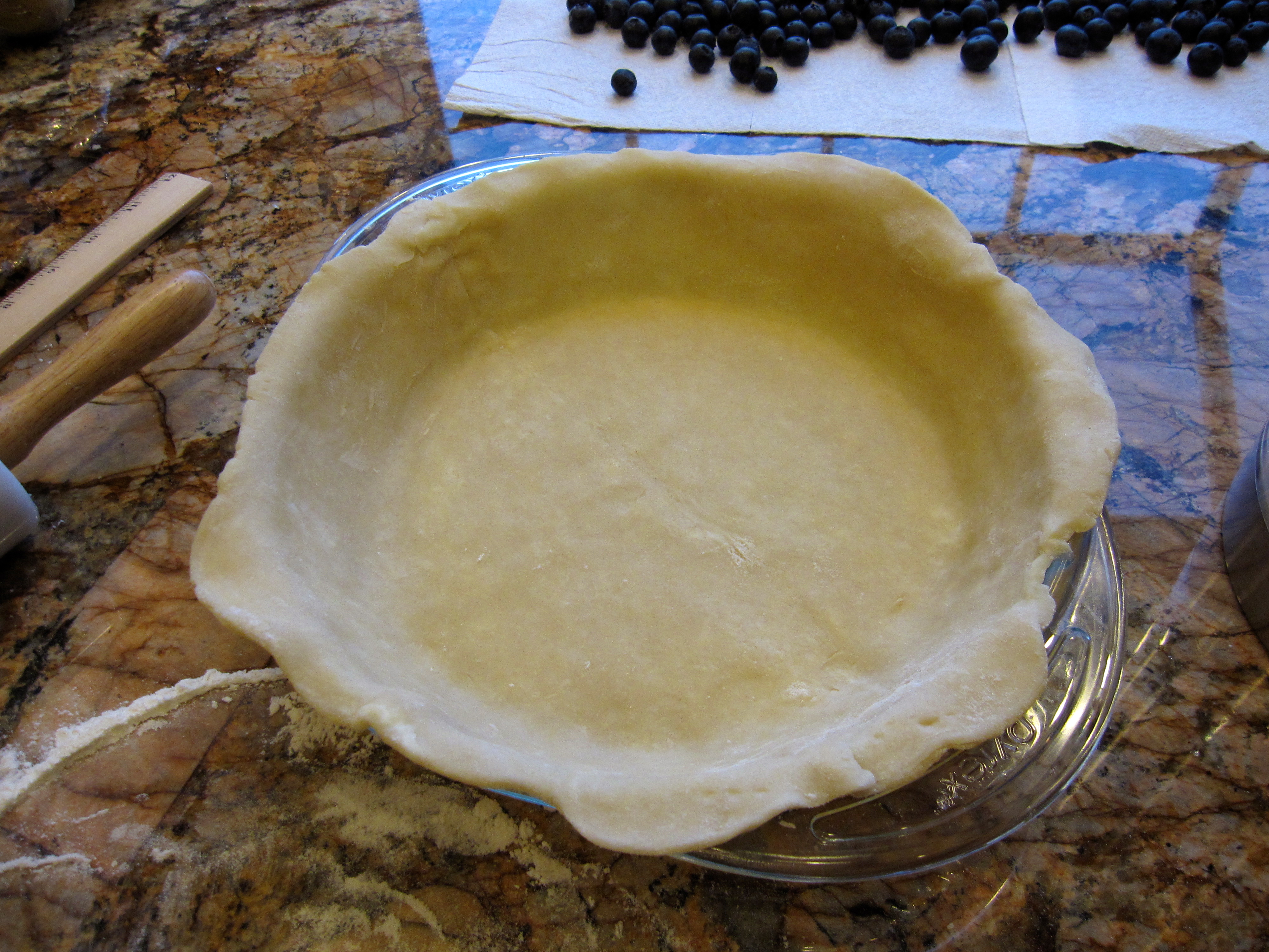 Pie dough in glass pie plate.