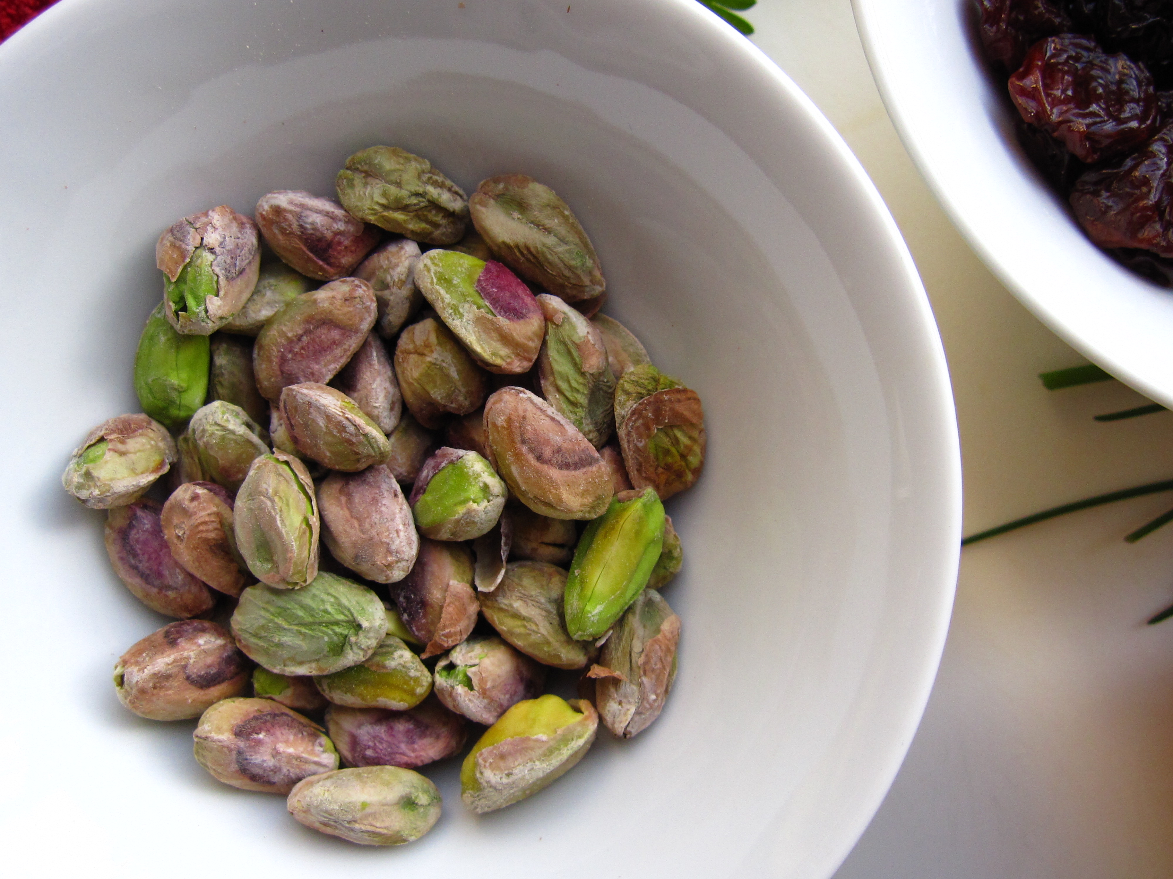 Shelled pistachios in a white bowl.