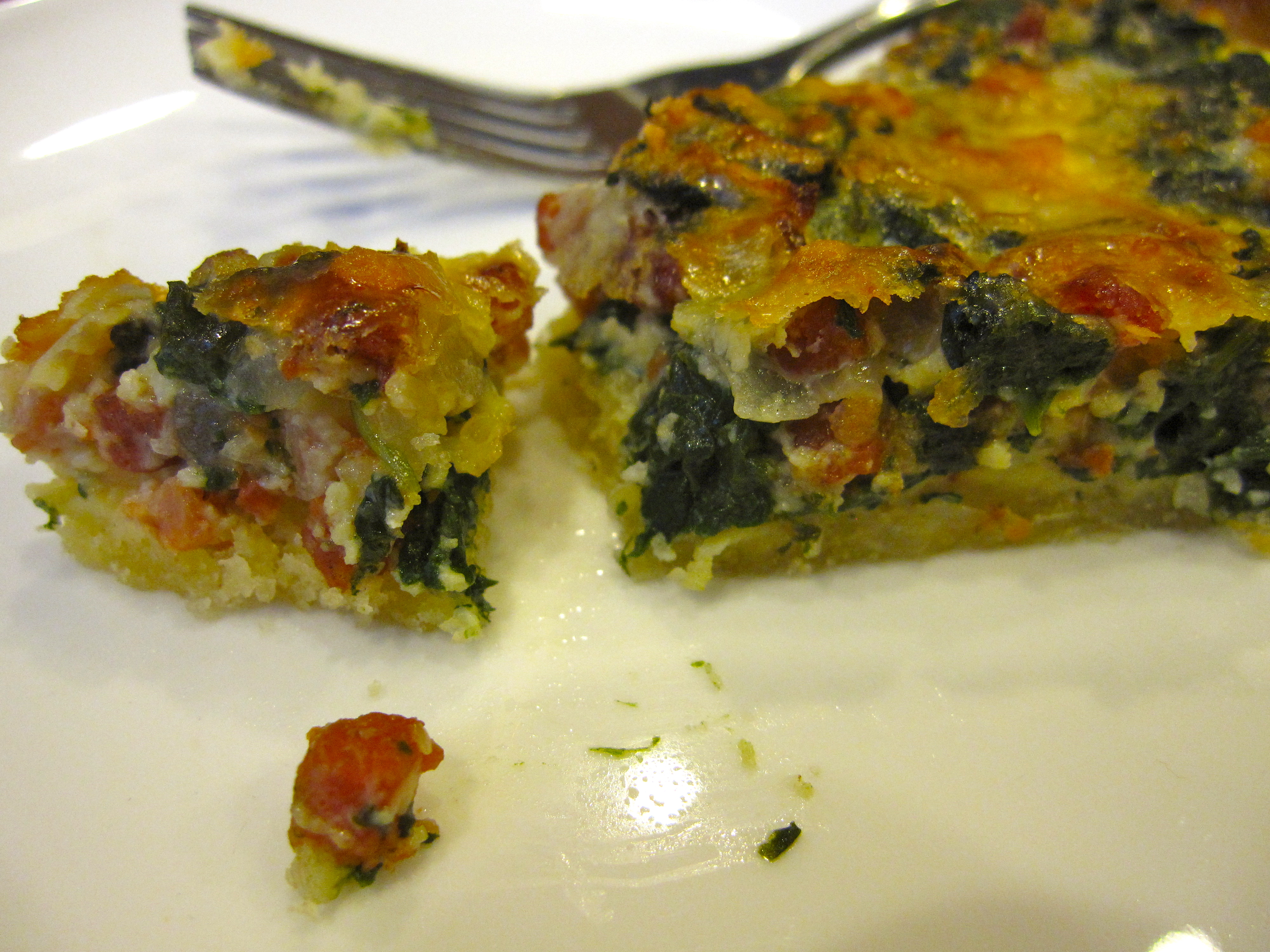 Dorie Greenspan's Spinach and Bacon Quiche on a white plate with a fork.