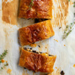 pinterest image showing 3 slices of vegetarian wellington on baked parchment paper