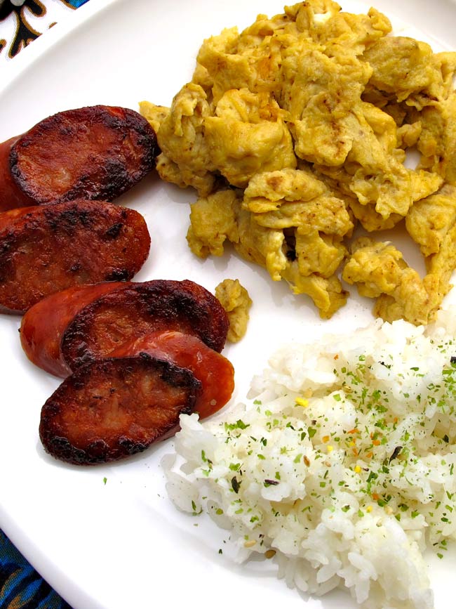 Portuguese sausage rice and eggs on white plate.