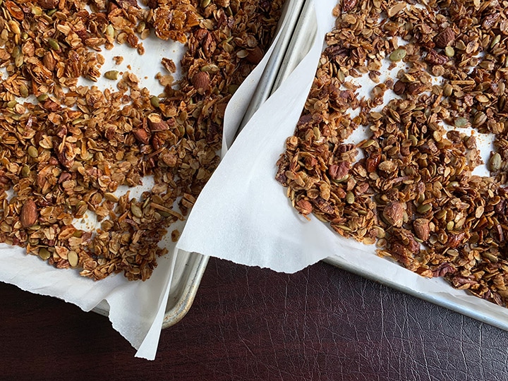 Cooked olive oil granola on two sheets trays.