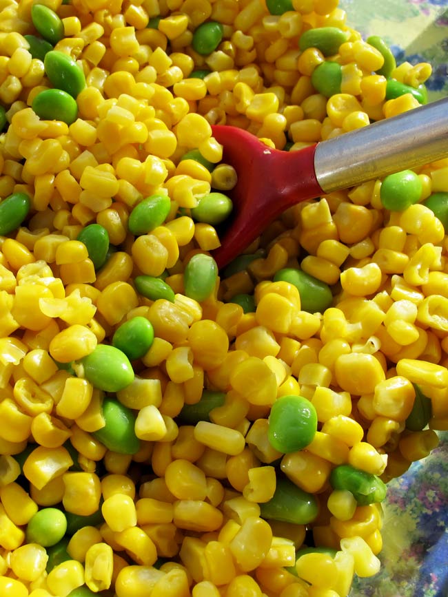 corn and edamame with red spoon