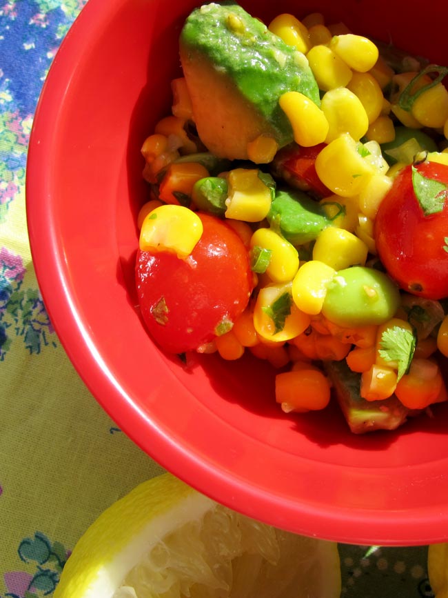 make-ahead corn salad in red bowl with sunlight