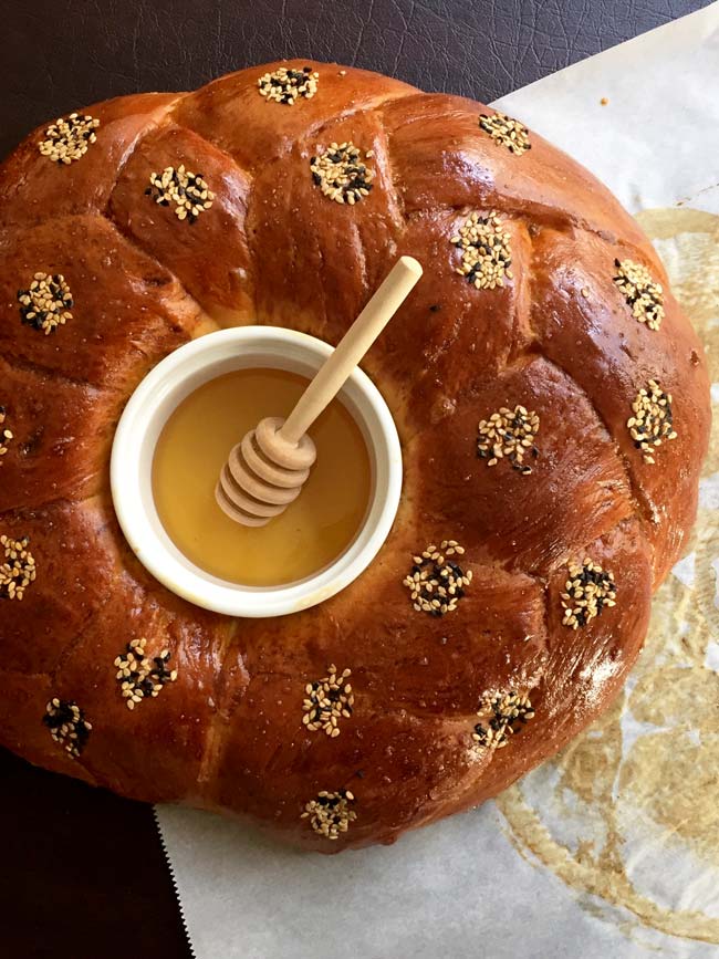 Round challah with honey in the center.