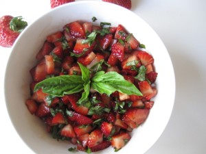 A white bowl with chopped strawberry salsa.