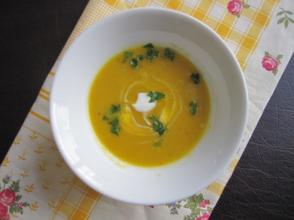 A white soup bowl filled with squash soup.