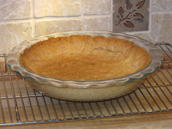 Baked macadamia crust cooling on a rack.