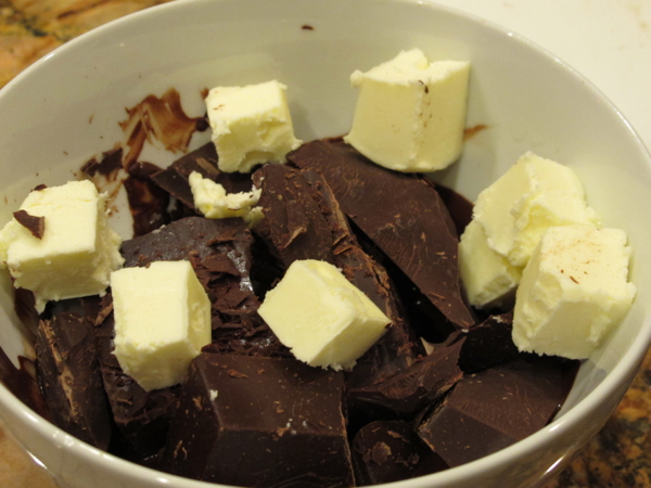 A bowl with chocolate and butter chunks, ready for melting.