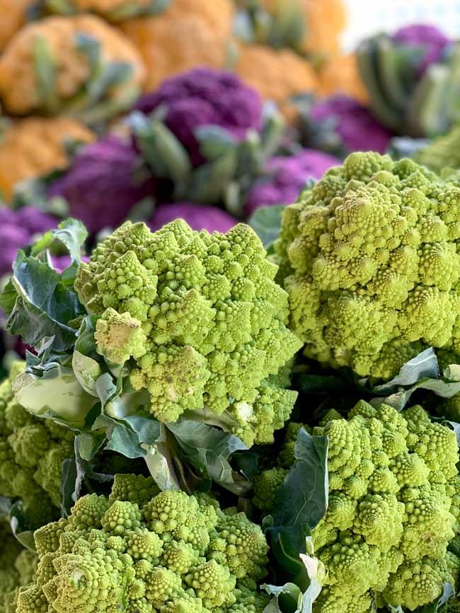 Display of green, purple, and  orange cauliflower.