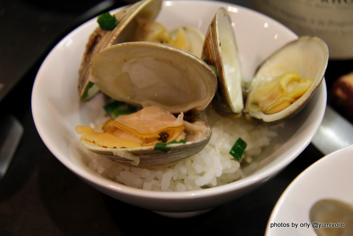 A serving of sake steamed clams in a rice bowl on Japanese rice. 