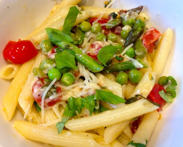 Farmer's Market Pasta with asparagus, peas and cherry tomatoes on a white plate ready for serving.