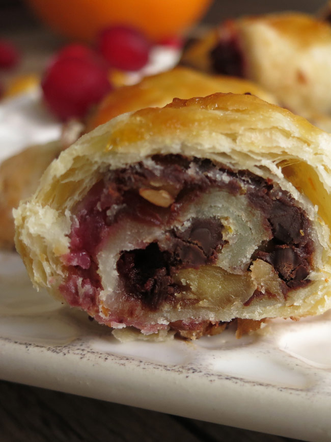 Close up of cross section of orange cranberry rugelach, showing filling and flakey interior.
