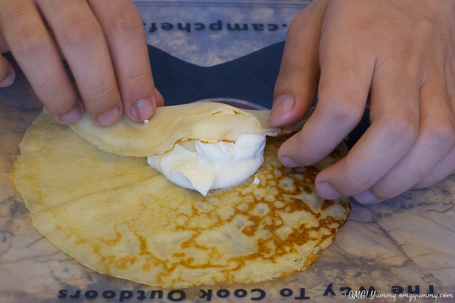 French crepes being rolled around filling.