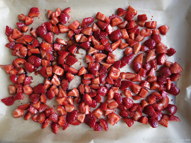 Chopped, roasted strawberries on parchment before baking.