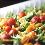 Tomato, Corn, and Arugula Salad on a white platter
