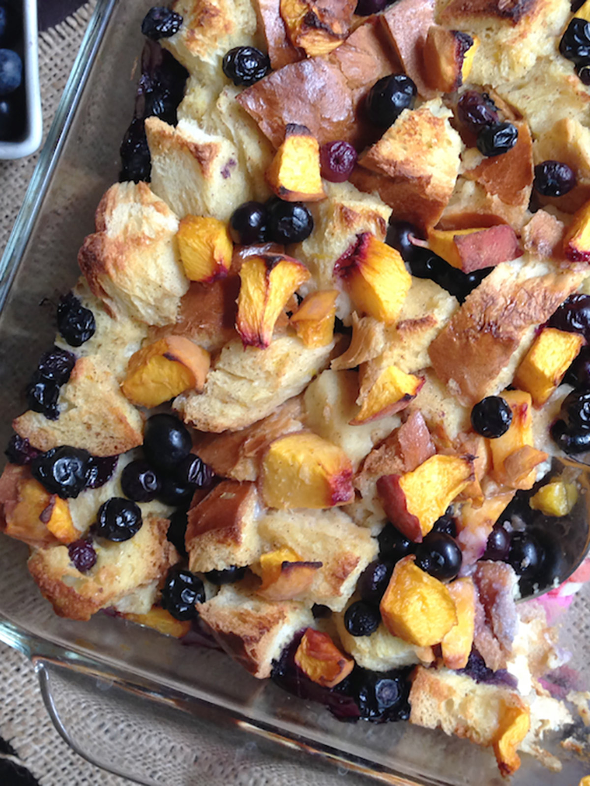 Baked challah bread pudding in glass baking dish.