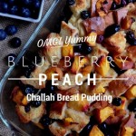 Challah bread pudding with peaches and blueberries in a glass baking dish.
