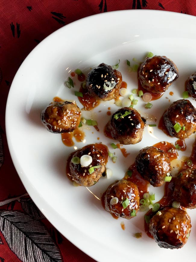 spicy korean meatballs on white plate with red napkin