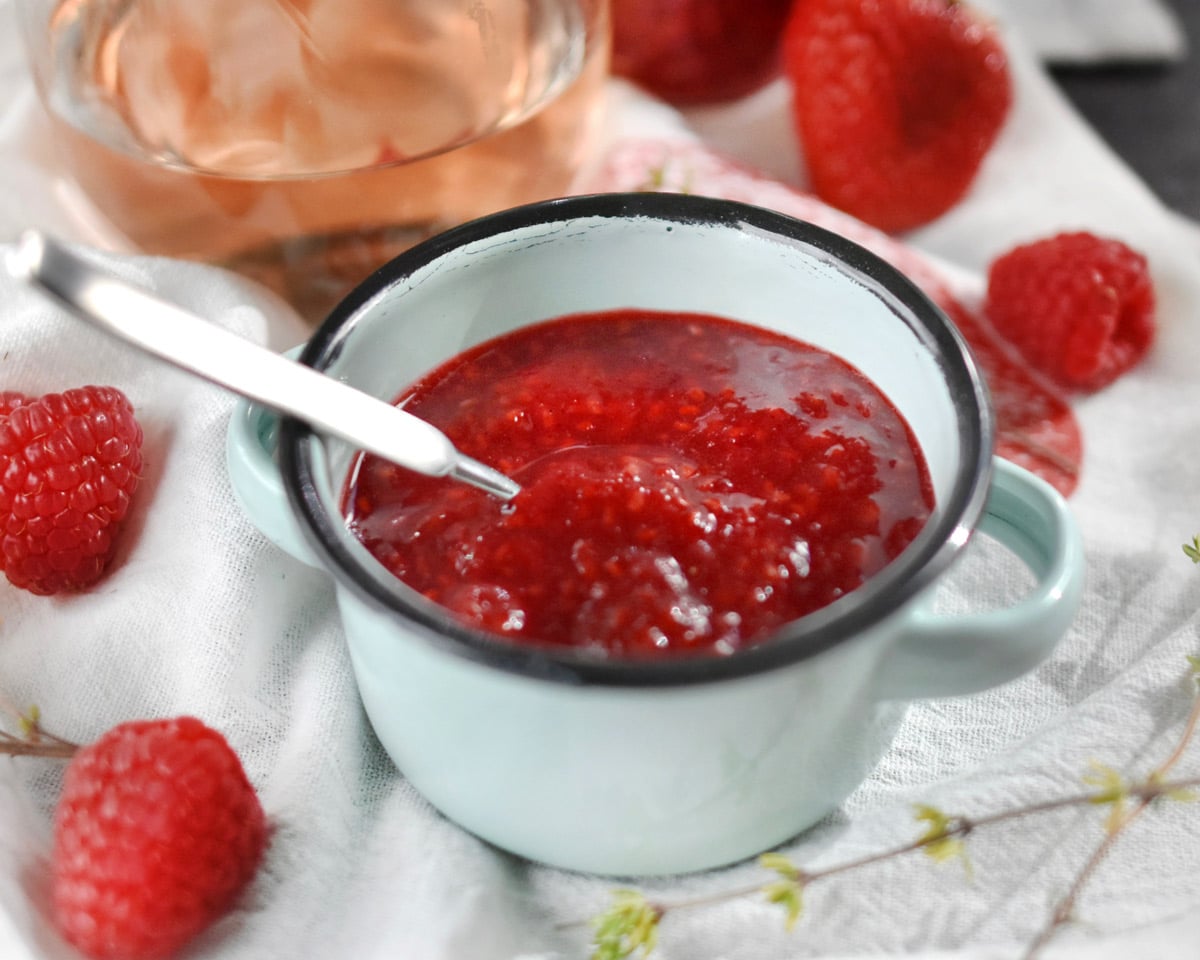 Gregory's strawberry raspberry jam with rose wine in the background.