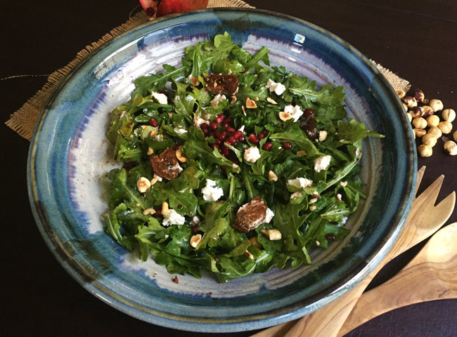 fig salad in blue bowl with serving utensils