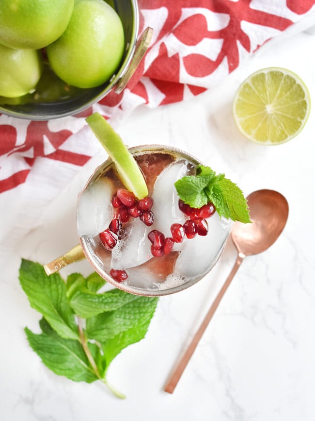 cocktail with pomegranate molasses overhead shot in a copper mug with copper spoon