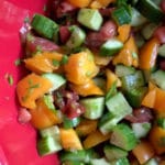cucumber tomato salad in a red bowl for a pinterest image
