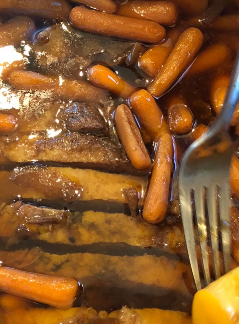 Instant Pot Brisket sliced and back in pot with carrots and potatoes.
