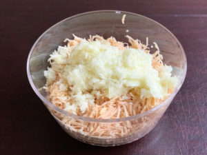 onions and potatoes for latkes in clear bowl unmixed