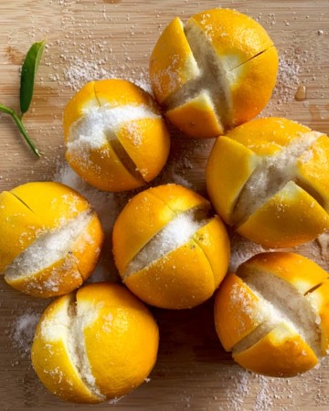Ottolenghi Preserved Lemons top down view of split lemons filled with salt on bamboo cutting board