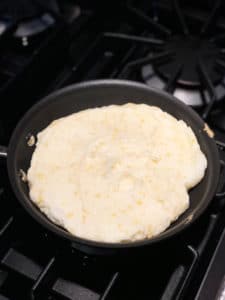 matzo meal pancake in frying pan before flipping