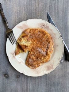 matzo meal pancake with cinnamon sugar on plate with knife and fork