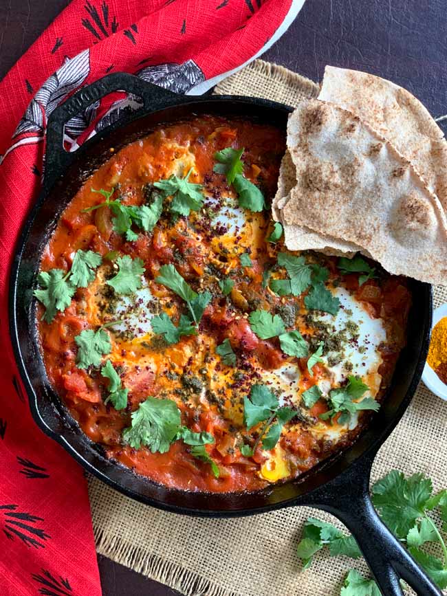 Shakshuka in cast iron pan with pita bread.