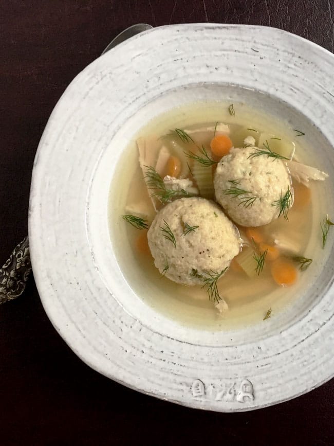 matzo ball soup in a white bowl