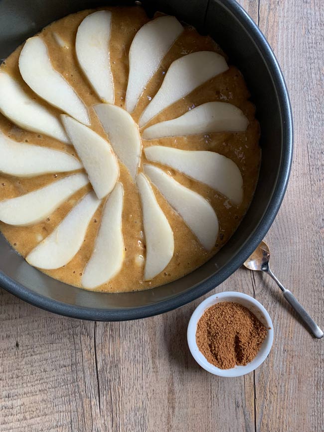 Pear cake batter in round pan with cinnamon sugar, ready to go into the oven.
