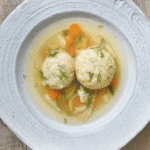 matzo ball soup in white bowl pinterest image