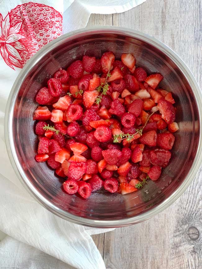 Fresh strawberry raspberry jam ingredients in bowl ready to macerate.