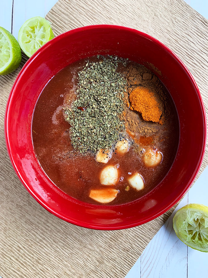 Carnitas ingredients in a red bowl.