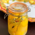 Jar of preserved lemons with lemon plate in the background