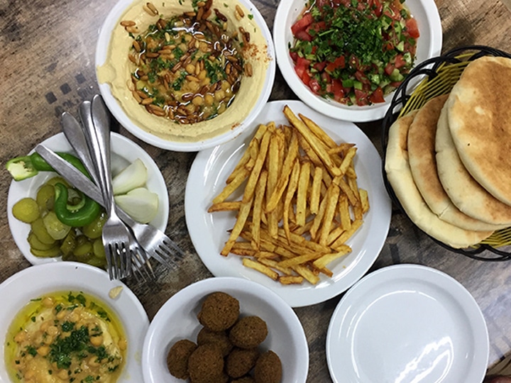 lunch spread of hummus, pickles, chopped salad, pita, falafel and french fries in the Muslim Quarter of the Old City of Jerusalem