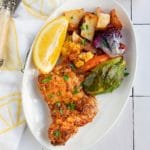 chicken and vegetables on white plate with lemon napkin