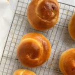 Challah rolls on a cooling rack.