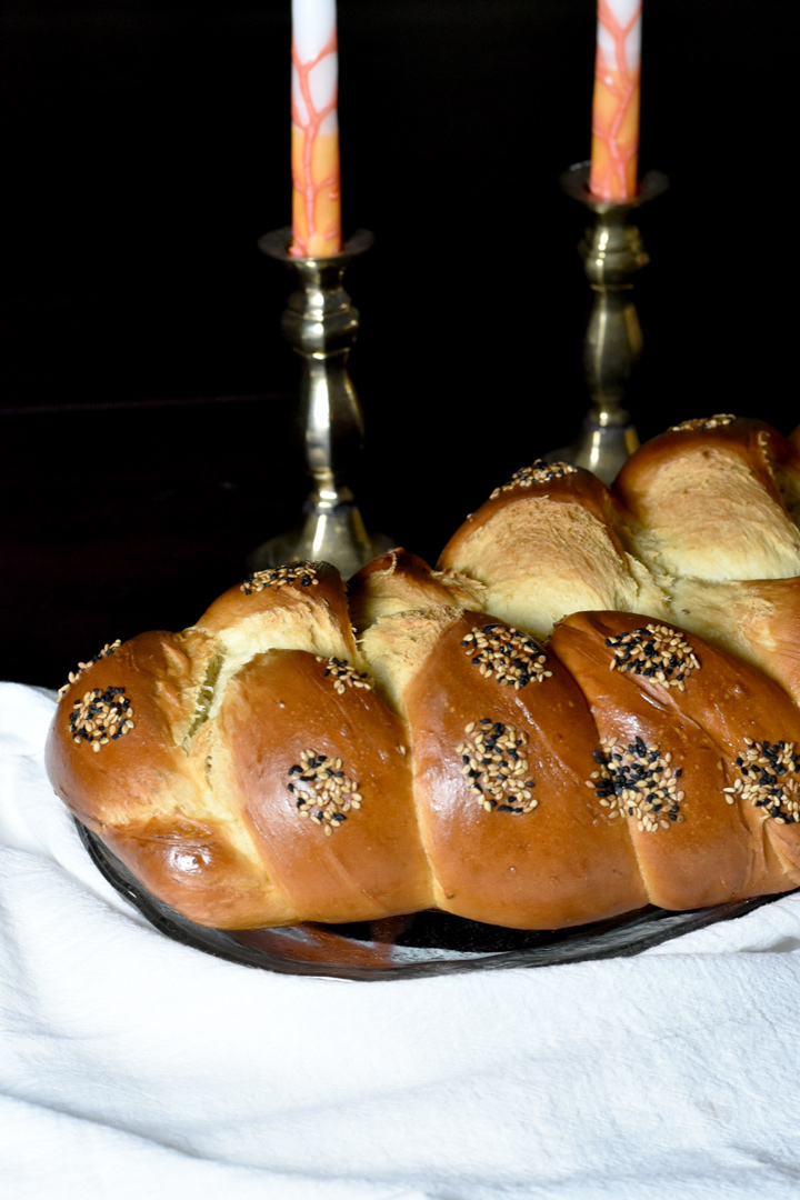 Challah bread in front of Shabbat candles.