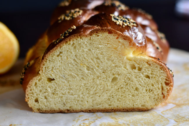 Cut open baked challah with a close up to show the crumb of the bread.