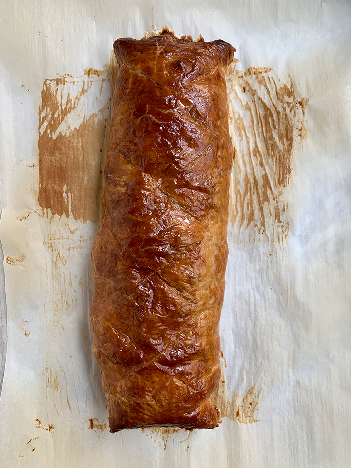 fully baked wellington on baked parchment ready to be sliced